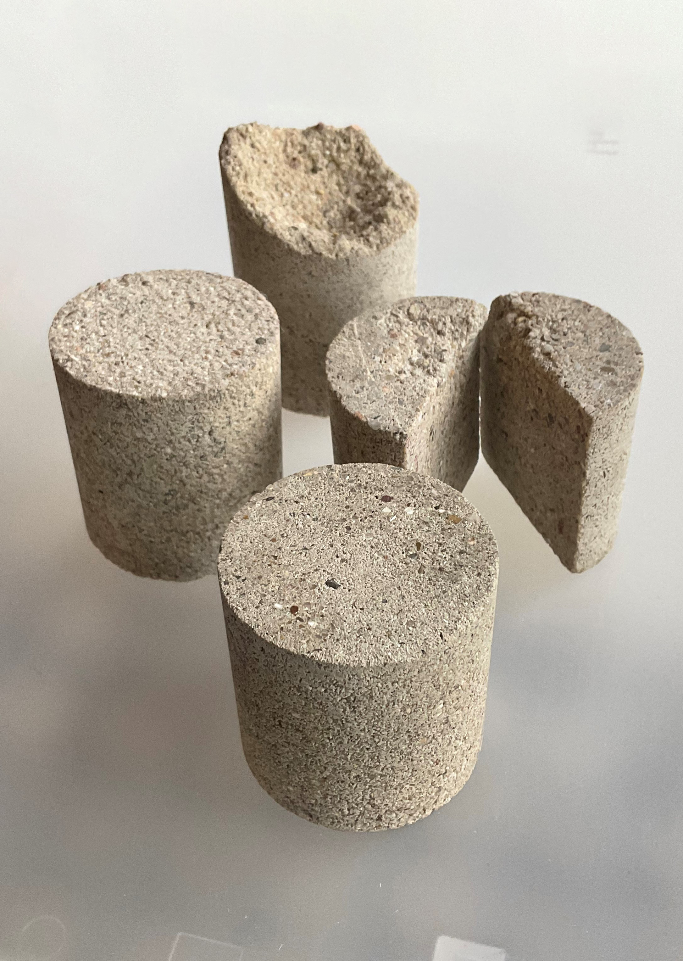 The figure shows different sized and partially cut open cylindrical parts made of bioconcrete.