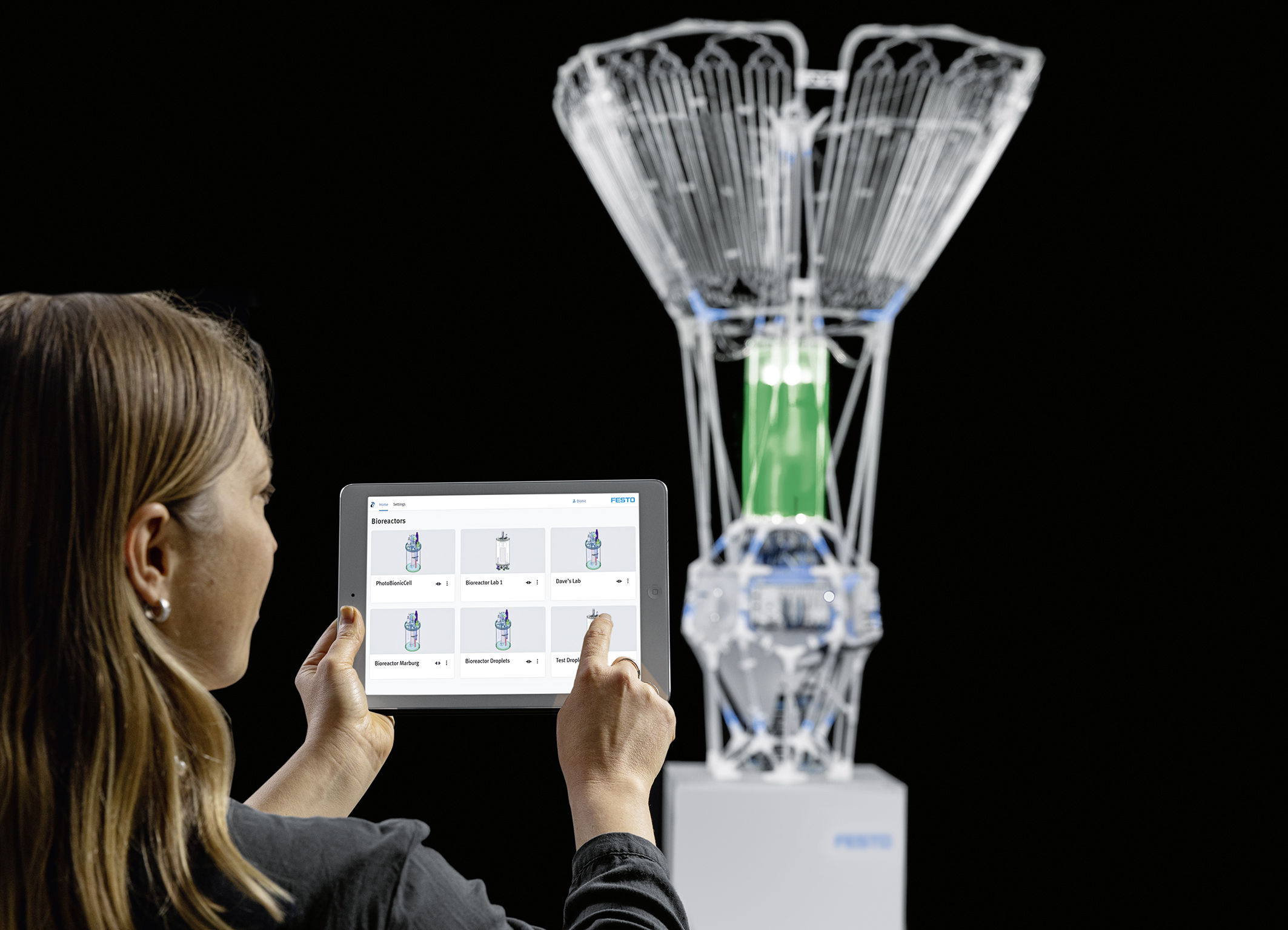A user with a tablet reading data in front of the bioreactor
