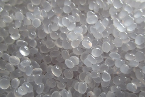 Close-up of the transparent granules. The photo shows a handful lentil-sized granules.