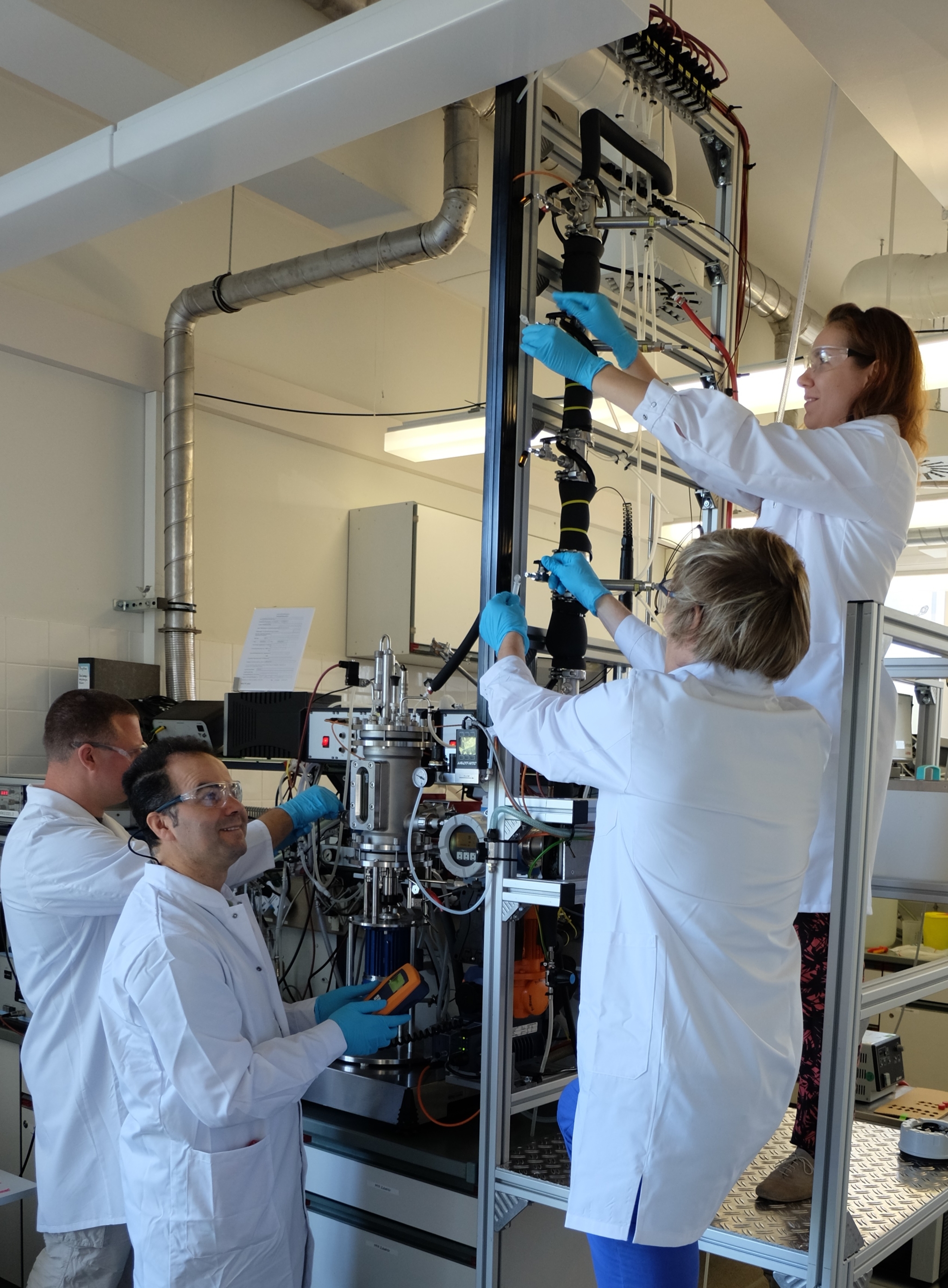 The IBVT team (from right to left) - Joana Siemen, Michael Löffler, Salah Lagrami and Alexander Broicher – adjusting the experimental system that they use to generate key data required for the simulation of large-scale production.