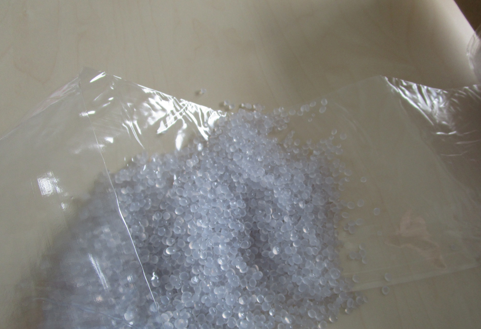 The photo shows a transparent foil alongside the granules used to produce it.