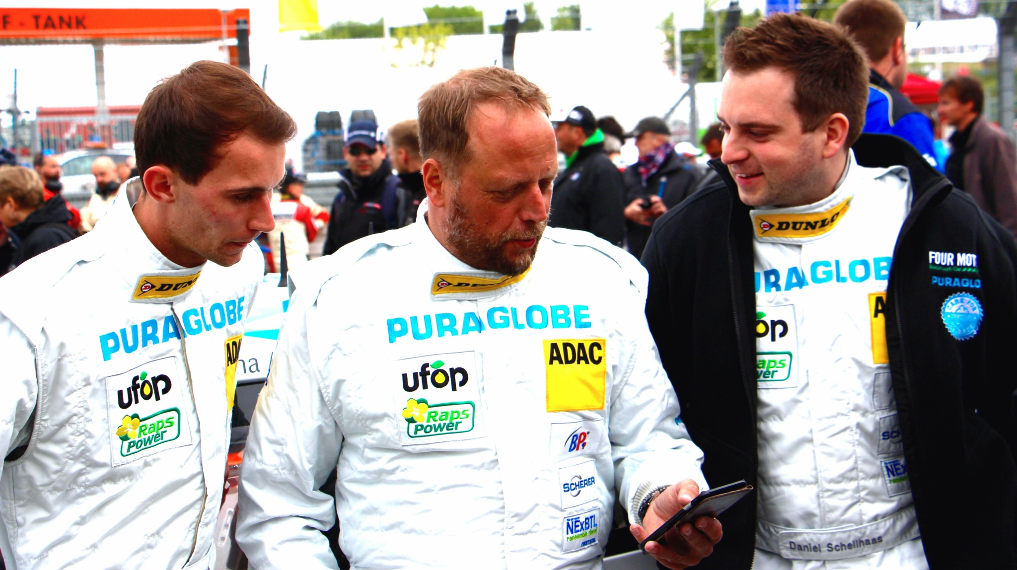 Photo of Smudo and two other members of the Four Motors team wearing white race suits.