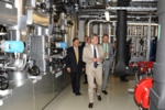 Bild zeigt die Besucher beim Rundgang in der Energiezentrale, viele Rohre, Leitungen und dazwischen Vetter mit EU-Kommissar Oettinger.
