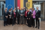 Eine Gruppe baden-württembergischer Politiker versammelt sich für ein Gruppenfoto vor den Fahnen von Deutschland und Europa.