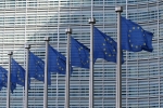 Europäische Flaggen mit einem Gebäude im Hintergrund.