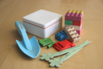 The photo shows a children's shovel, plugs, letter openers, tiles, a rectangular fox and a buckle.