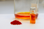 Orangefarbenes Fucoxanthin, als Pulver und gelöst in einem Glasfläschchen