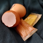 Neben zwei leeren Eierschalen liegen zwei Tütchen aus der neuartigen Folie gefüllt mit Gewürzen.